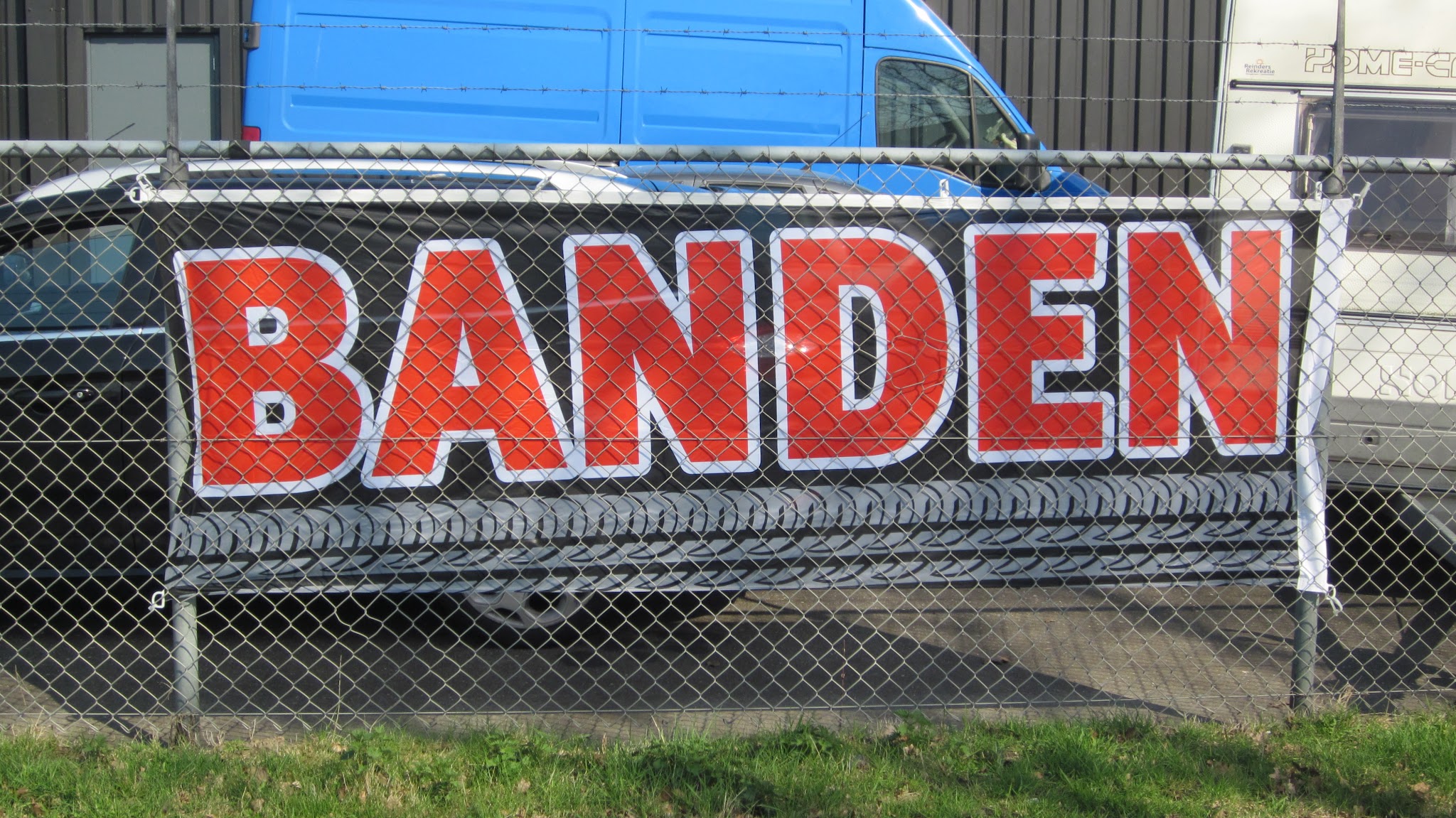 Rood spandoek met het woord BANDEN aan een hek